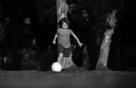 Photo for Little kid boy playing football in the field with soccer ball. Concept of children sport. Child soccer player in park - Royalty Free Image