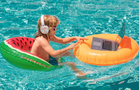 Photo for Kids working with laptop on summer vacation holidays. Little freelancer using computer, remote working in swimming pool. Summer business and online technology - Royalty Free Image