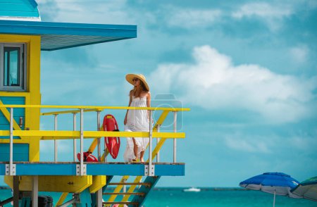 Téléchargez les photos : Beautiful woman walking on the miami south beach. Girl walk near miami beach lifeguard - en image libre de droit
