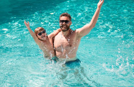 Téléchargez les photos : Père et fils nagent dans la piscine, famille d'été. Week-end actif - en image libre de droit