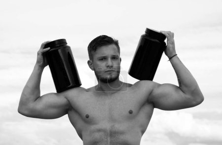 Foto de Nutrición deportiva. Hombre musculoso, atlético con nutrición deportiva. Hombre muscular con proteína, fuerte torso desnudo masculino - Imagen libre de derechos