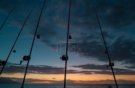 Foto de Pesca curricán en soporte de caña. Pesca de caza mayor. Patrón de carretes y cañas de pesca en el mar. Cañas de pescar oceánicas - Imagen libre de derechos