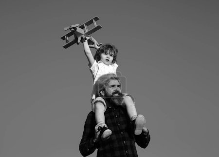 Téléchargez les photos : Le père qui ramène son fils au parc. Père et fils jouant avec jouet avion en plein air. Vacances en famille, parentalité. Fête des pères - en image libre de droit