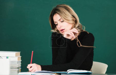 Photo for Pretty young high school or college teacher on the chalkboard. Young caucasian female business woman portrait with blackboard background - Royalty Free Image