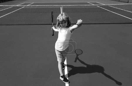 Téléchargez les photos : Petit garçon mignon jouant au tennis sur le court - en image libre de droit