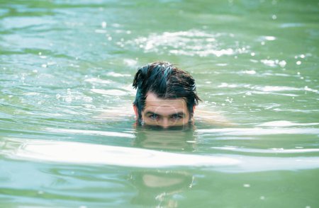 Téléchargez les photos : Un homme nageant dans l'eau. Week-end de vacances d'été - en image libre de droit