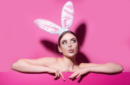 Photo for Easter young woman studio wearing bunny ears. curious isolated on pink - Royalty Free Image