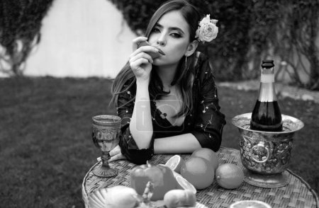 Foto de Retrato de verano de una hermosa mujer de moda comiendo naranja, frutas sexy de verano al aire libre - Imagen libre de derechos