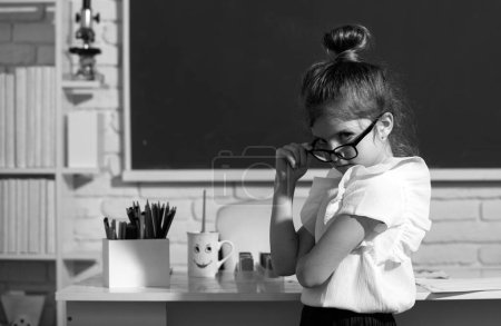 Foto de Colegiala nerd en gafas en pizarra. Retrato de alumna divertida de estudio de la escuela primaria - Imagen libre de derechos