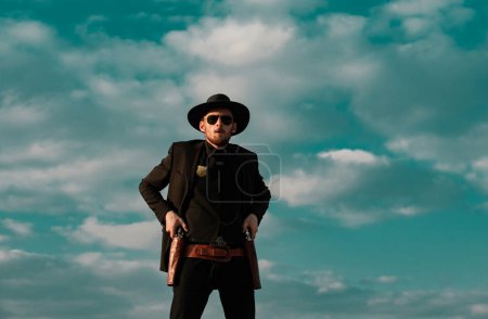Sheriff or marshal on sky. American western, wild west with cowboy. Serious guy with gun revolver weapon outdoor
