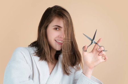 Women hair care. Portrait of happy young woman having her hair cut with scissors