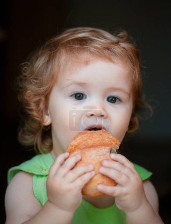 Baby with bread. Cute toddler child eating sandwich, self feeding concept