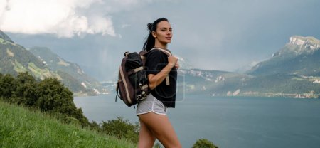 Foto de Viajes y turismo. El senderismo. Mujer en las montañas. Mujeres excursionistas trekking en las montañas. Mujer joven caminando con mochilas en el lago de los Alpes. Mujer con gran mochila en las montañas y el lago azul - Imagen libre de derechos