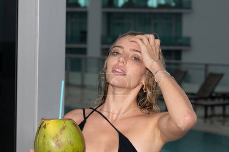 Téléchargez les photos : Portrait de femme sexy d'été avec boisson à la noix de coco. Vacances d'été. Vacances tropicales. Fashion model girl pendant des vacances tropicales. Reste dans le luxe vila et station balnéaire - en image libre de droit