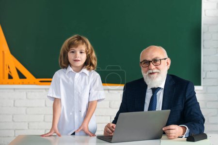 Photo for Teacher sharing experiece with pupil in classroom. Education concept. School learning concept. Boy elementary school. Old and Young - Royalty Free Image