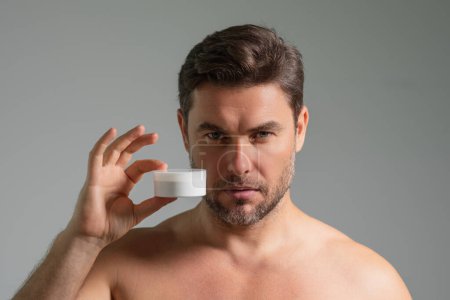 Handsome aged man applying face cream. Beauty routine. Man with perfect skin. Anti-aging and wrinkle cream. Concept of male beauty. Close up face of man applying cream to skin. Skincare and cosmetics
