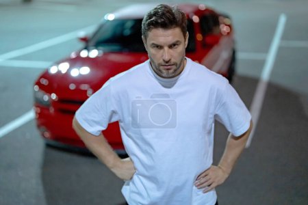 Photo for Gangster, criminal concept. Angry man near car on night urban street. Dangerous aggressive man with serious face. Criminal city. Danger american district. Aggressive angry fighter man. Displeased guy - Royalty Free Image