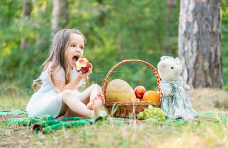 Cute child with autumn picnic basket. Sunny park or garden. Little girl in forest camp