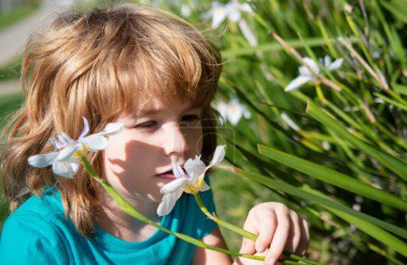 Photo for Spring boy smelling flower outdoor. Kids allergy. Kid sniffing white flowers - Royalty Free Image