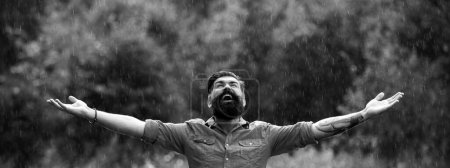 Foto de Hombre barbudo bajo la lluvia. Lluvia de otoño. Concepto de relajación. Pensamiento positivo. Tiempo tormentoso - Imagen libre de derechos