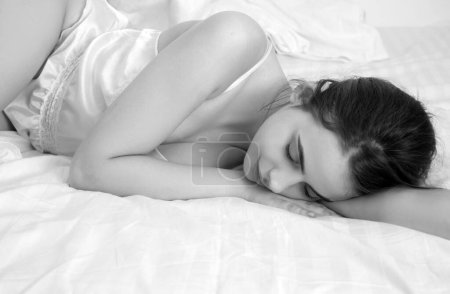 Photo for Young woman sleeping well in bed hugging soft white pillow. Girl resting, good night sleep. Sweet dreams - Royalty Free Image