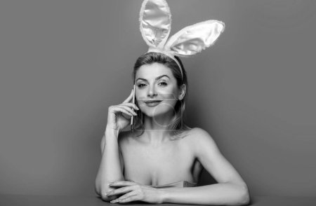 Photo for Easter woman with bunny ears talking on the phone isolated on pink banner, copy space - Royalty Free Image
