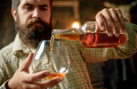 Photo for Degustation, tasting. Man with beard holds glass of brandy - Royalty Free Image