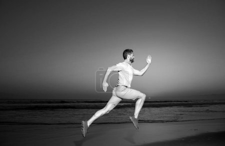 Photo for Man running on the beach at sunset. Athletic young man running in the nature - Royalty Free Image
