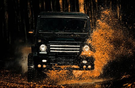 Mud and water splash in off-road racing. Off the road travel on mountain road. Track on mud. Expedition offroader. 4x4 Off-road suv car. Offroad car. Safari. Tires in preparation for race