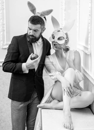 Photo for Lovely couple in rabbit costumes having fun with rabbit ears. Concept of honeymoon. Bold adult games. Happy family preparing for Easter - Royalty Free Image