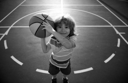 Kid little boy playing basketball with basket ball