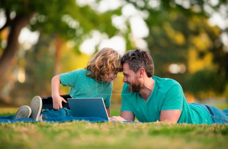Téléchargez les photos : Heureux père et fils profitant de l'heure d'été en vacances dans un parc ensoleillé. Leçon en ligne - en image libre de droit