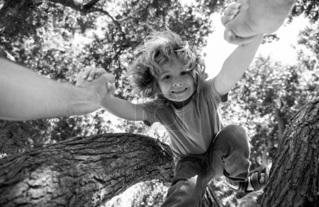 Father helping son to climb tree. Fathers hand. Child protection. Healthy parenting lifestyle