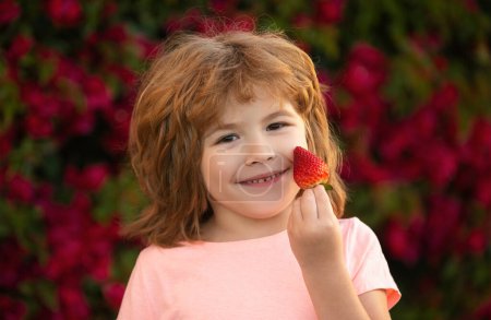 Photo for Healthy kids food Kid funny portrait. Cute little boy eating a strawberry - Royalty Free Image