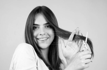 Photo for Smiling woman with scissors having hair cut. Beautiful girl with straight hair with professional scissor. Haircare concept - Royalty Free Image