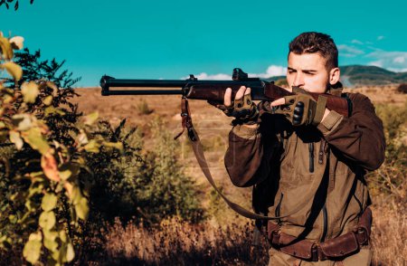 Jäger mit leistungsstarkem Gewehr mit Zielfernrohr, das Tiere beobachtet. Jäger mit Gewehr auf Jagd. Spurensuche