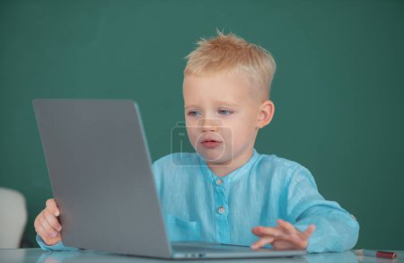 Téléchargez les photos : Enfant utilisant des gadgets pour étudier. Éducation informatique pour les enfants. Petit programmeur drôle. Programmation enfant géniale, formation informatique - en image libre de droit