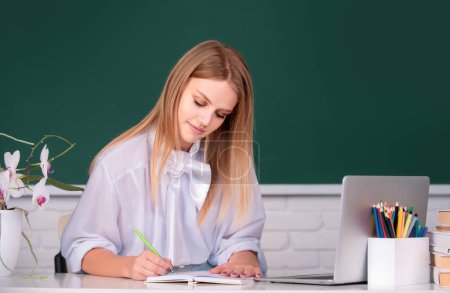 Photo for Portrait of female university student study lesson, writing on notebook at school or university - Royalty Free Image