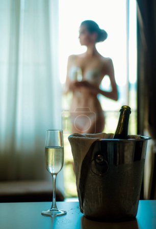 nackte verschwommene Frau auf Champagnerglashintergrund. Liebespaar nach oder vor Sex im Schlafzimmer