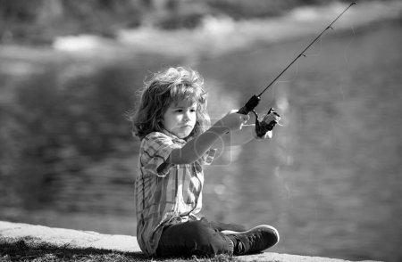 Foto de Feliz pesca infantil. Chico con spinner en el río. Concepto de pesca - Imagen libre de derechos