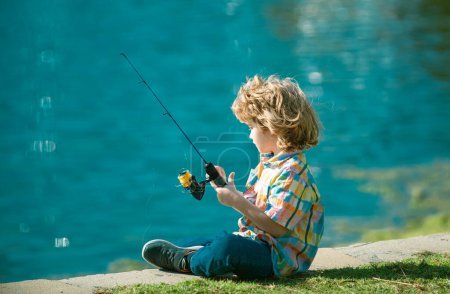 Foto de Pasatiempo de pesca. Chico con spinner en el río. Niño en embarcadero con varilla - Imagen libre de derechos