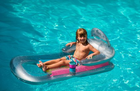 Téléchargez les photos : Vacances d'été. Enfant dans la piscine. Garçon nageant à la piscine. Enfant drôle sur matelas gonflable en caoutchouc - en image libre de droit