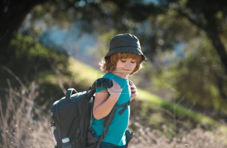 Kids with backpack hiking. Boy child local tourist goes on a local hike