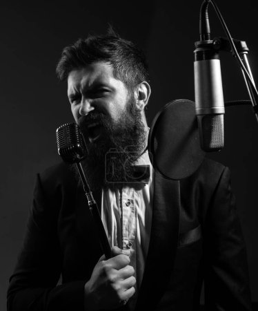 Retrato de hombre barbudo con micrófono cantando canción. Músico en music hall. Un tipo gracioso cantando en karaoke. Expresión cara de cerca