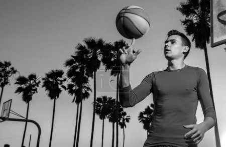 Jugador de baloncesto. Balón de cesta giratorio a mano. Balanceo de baloncesto en el dedo. Deportes y baloncesto