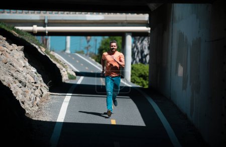 Foto de Joven atlético. Corredor corriendo hombre corriendo entrenamiento en la carretera de la ciudad - Imagen libre de derechos