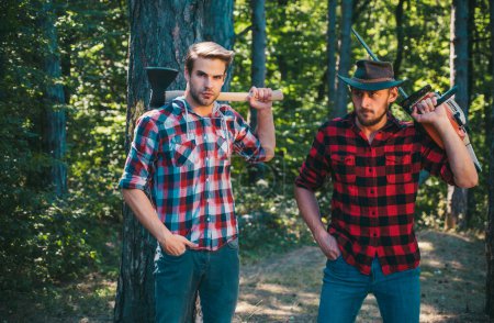 Male lumberjack in the forest. Woodcutter with axe and lumberjack with chainsaw. Lumberjack style. Man woodcutter with ax. Strong man with axes