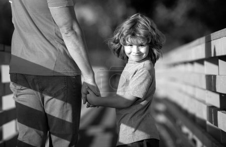 Foto de Feliz hijo extendiendo las manos padre. Hombre guapo y lindo chico al aire libre - Imagen libre de derechos