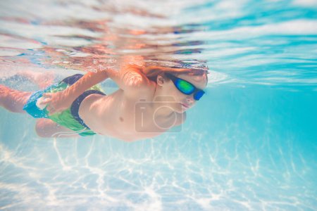 Photo for Child in swimming in pool. Funny little boy swims underwater in the pool. Underwater kids portrait from under the water. Summer holiday. Kids weekend - Royalty Free Image