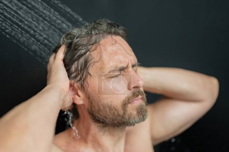 Photo for Portrait of man washing hair with shampoo taking shower. Washing hair with shampoo. Man washing hair with anti-dandruff shampoo, taking a shower. Hair care product, foam gel, shampoo and lotion - Royalty Free Image